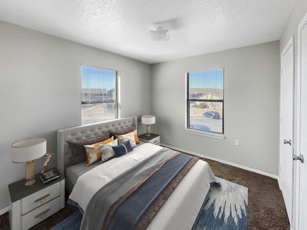 A bedroom with a large bed and a window overlooking a parking lot.